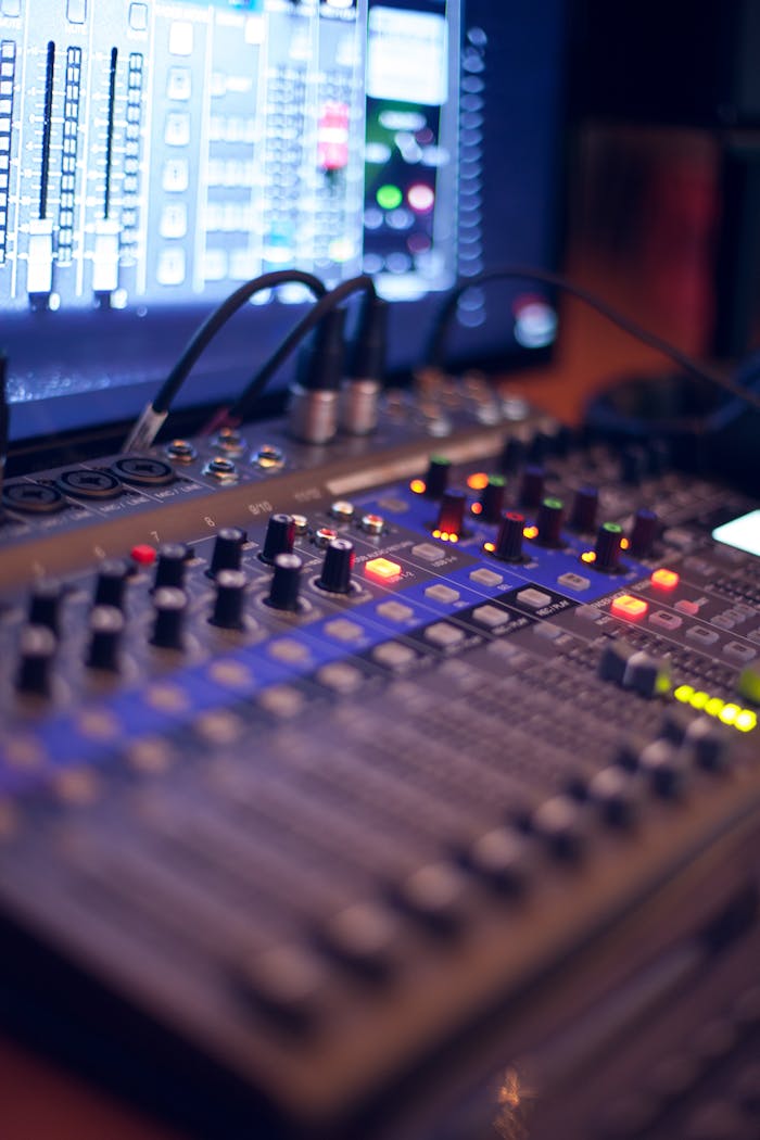 Close-up of a professional audio mixing console with glowing LED indicators.